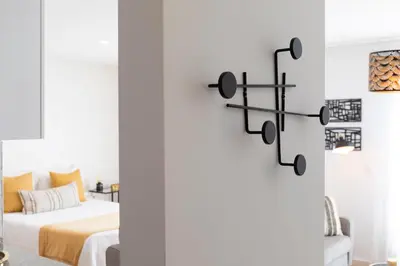 a bedroom with a bed and a white wall at FT'Studio in Porto