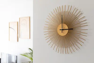 a gold sunburst clock hanging on a wall at FT'Studio in Porto