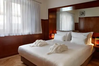 a bedroom with a large white bed with towels on it at Casa Rosa in Porto