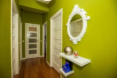 a green hallway with a mirror on a green wall at ML Apartments Charming Rooms in Porto