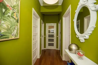 a hallway with green walls and a mirror at ML Apartments Charming Rooms in Porto