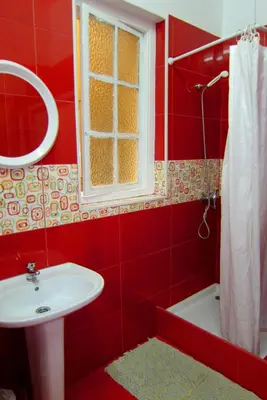 a red bathroom with a sink and a window at Duas Nações Guest House in Porto