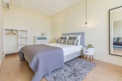 a living room with a blue couch and a tv at Trindade Flat with Great View in Porto