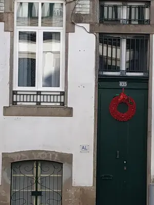 a green door with a red wreath next to two windows at Gabriel Guesthouse in Porto