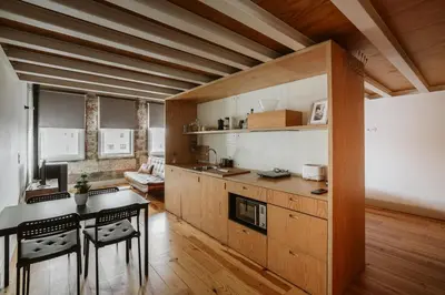 a kitchen with wooden cabinets and a table and chairs at Step In Porto Apartments in Porto