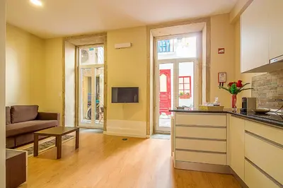 a kitchen and living room with a couch and a table at São Domingos Flowers Apartments in Porto