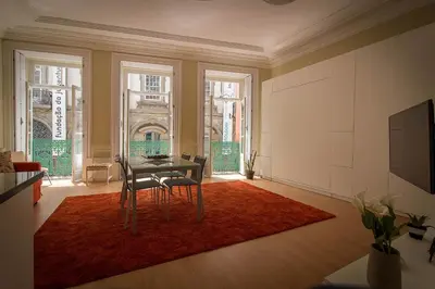 a dining room with a table and chairs on a red rug at São Domingos Flowers Apartments in Porto