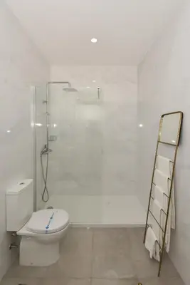 a white bathroom with a toilet and a shower at Rosario's Boutique Apartments in Porto