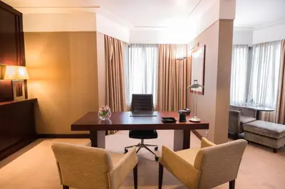 a room with a desk and chairs in a hotel room at Crowne Plaza Porto by IHG in Porto