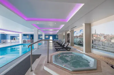 a swimming pool with a hot tub in a building at Vila Gale Porto - Centro in Porto