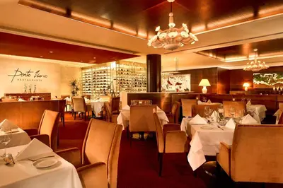 a restaurant with white tables and chairs and a bar at Sheraton Porto Hotel & Spa in Porto