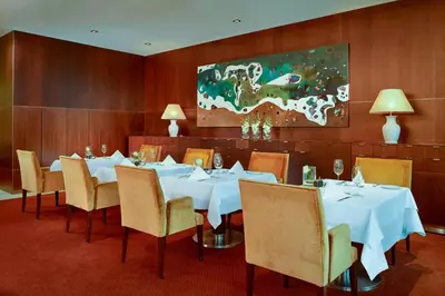a dining room with white tables and chairs and a painting at Sheraton Porto Hotel & Spa in Porto