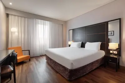 a hotel room with a large bed and a desk at Eurostars das Artes in Porto
