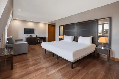 a large bedroom with a large bed and a desk at Eurostars das Artes in Porto