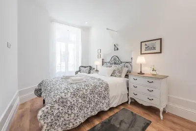 a white bedroom with a bed and a dresser at GuestReady - Feels like Heaven in Porto