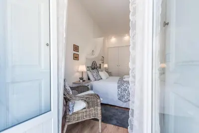 a bedroom with a bed and a chair and a window at GuestReady - Feels like Heaven in Porto