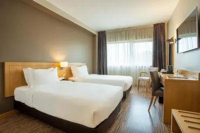a hotel room with two beds and a desk at HF Tuela Porto in Porto