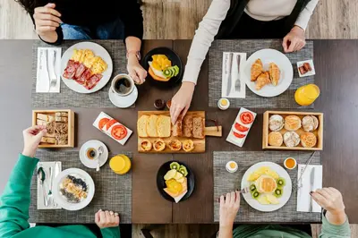 a group of people sitting around a table with breakfast foods at HF Tuela Porto in Porto