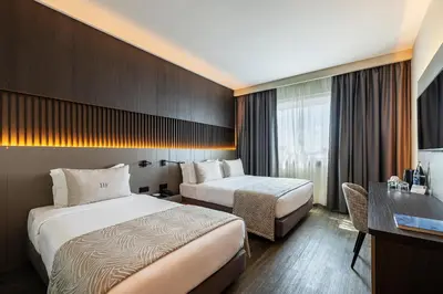 a hotel room with two beds and a desk at HF Ipanema Porto in Porto