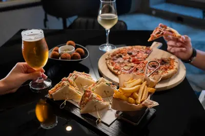 a table with a pizza and a plate of food at HF Fénix Porto in Porto