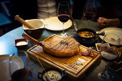 a table with a plate of food and glasses of wine at Pestana Vintage Porto Hotel & World Heritage Site in Porto