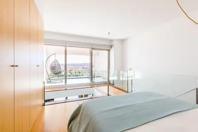 a bedroom with a bed and a window with the eiffel tower at CM Antas Studios in Porto