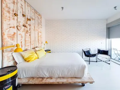 a bedroom with a large bed and two chairs at CM Antas Studios in Porto
