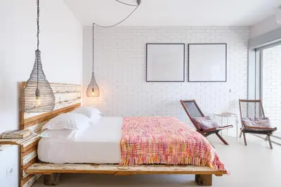 a bedroom with a wooden bed and two chairs at CM Antas Studios in Porto