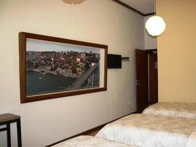 a room with two beds and a large picture on the wall at Pedra Iberica in Porto