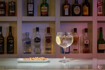 a glass of wine and a plate of food and bottles at TRYP by Wyndham Porto Centro Hotel in Porto
