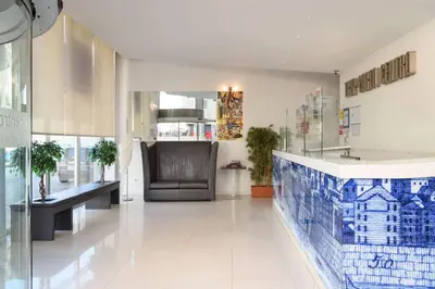 a lobby with a chair and a blue and white tile floor at TRYP by Wyndham Porto Centro Hotel in Porto