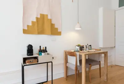 a table and chair in a room with white walls at Tripas-Coração, São Bento Apartments in Porto