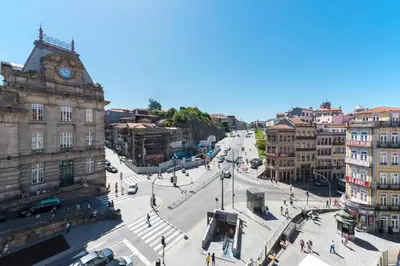 a city street with a clock tower on a building at Tripas-Coração, São Bento Apartments in Porto