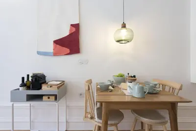 a dining room table with chairs and aendant light at Tripas-Coração, São Bento Apartments in Porto