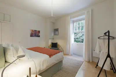 a white bedroom with a bed and a window at B28 Apartments Porto in Porto
