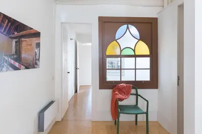 a green chair in a hallway with a window at B28 Apartments Porto in Porto