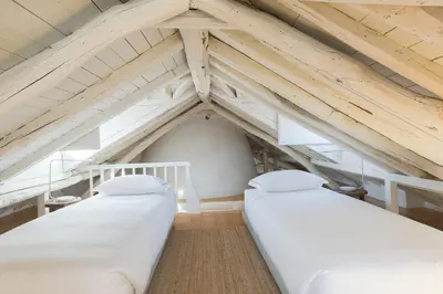 two beds in a attic room with wooden ceilings at B28 Apartments Porto in Porto