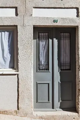 a gray door and two windows on a building at bnapartments Rio in Porto