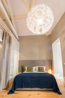 a bedroom with a large blue bed and a chandelier at bnapartments Rio in Porto