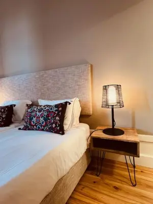 a bedroom with a bed with a lamp on a table at bnapartments Rio in Porto