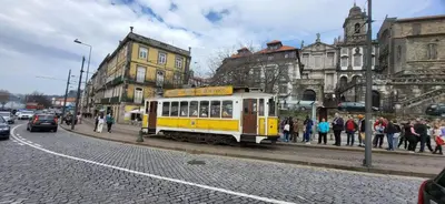 a yellow and white trolley car on a city street at CATS Porto Hostel in Porto