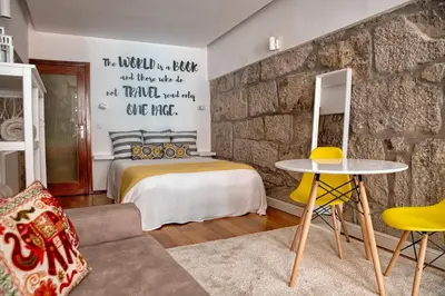 a bedroom with a bed and a stone wall at Try Oporto - Ribeira in Porto