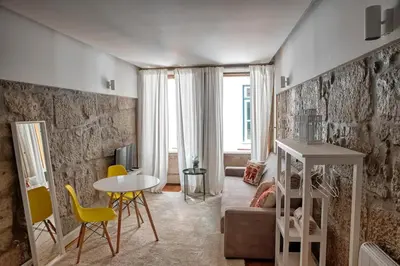 a living room with a table and yellow chairs at Try Oporto - Ribeira in Porto