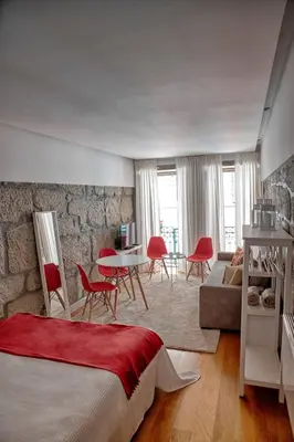 a bedroom with a bed and a table and chairs at Try Oporto - Ribeira in Porto