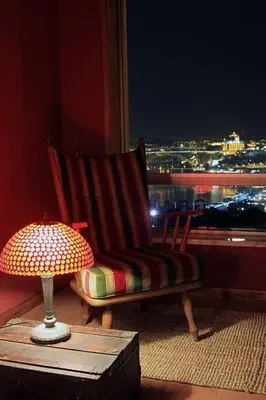 a lamp on a table next to a chair and a window at Historical Porto/Gaia Apartment in Porto