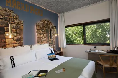 a hotel room with a bed and a desk and window at Casual Inca Porto in Porto