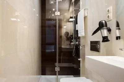 a bathroom with a shower and a toilet and a sink at Hotel da Bolsa in Porto