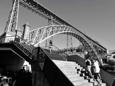 a group of people standing on stairs under a bridge at Oporto Delight 1 Luxury Apartment in Historic Center with Balcony Max 4 p in Porto