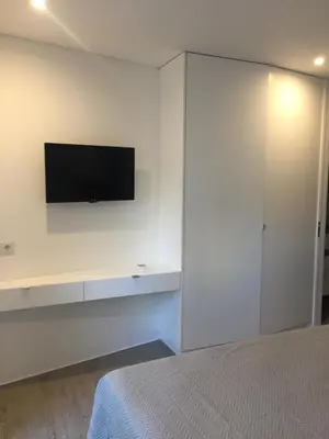 a bedroom with a tv on a white wall at SantOporto Baixa in Porto