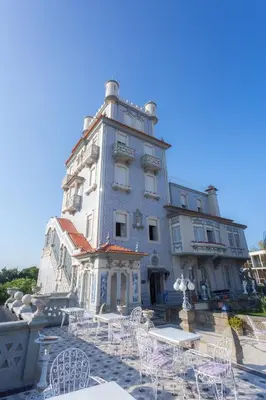 a building with chairs and tables in front of it at Castelo Santa Catarina in Porto